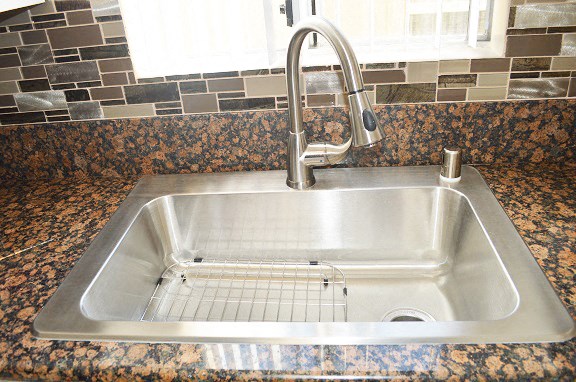 a stainless steel kitchen sink with a chrome faucet