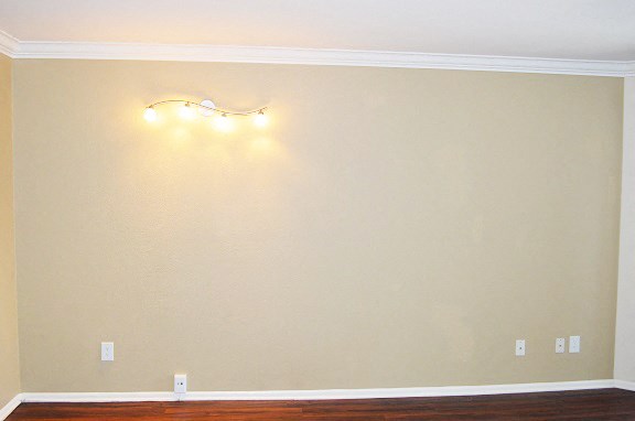 a empty room with a wooden floor and lights on the wall