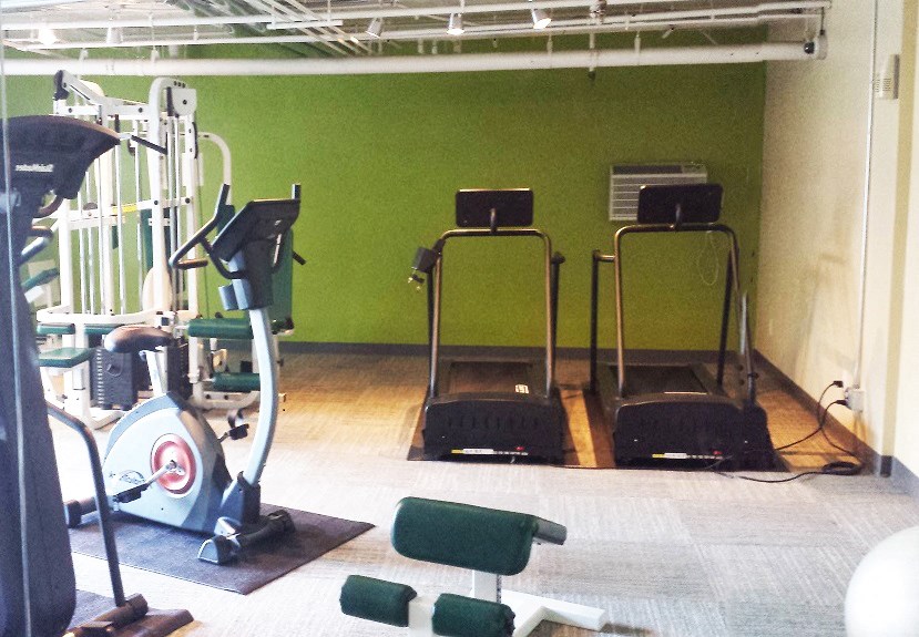 a gym with some machines and weights in it