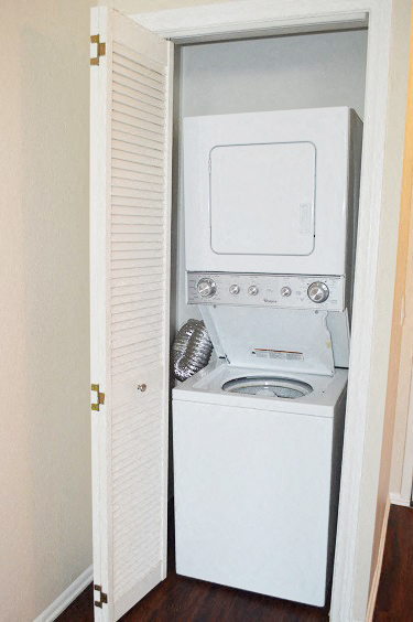 a white washer and dryer in a small closet