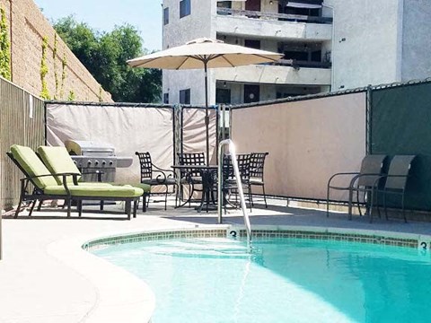 a swimming pool with chairs and an umbrella