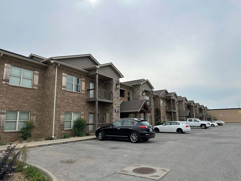 an empty parking lot in front of an apartment building