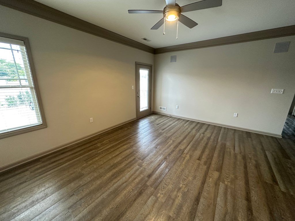 a living room with wood floors and a ceiling fan