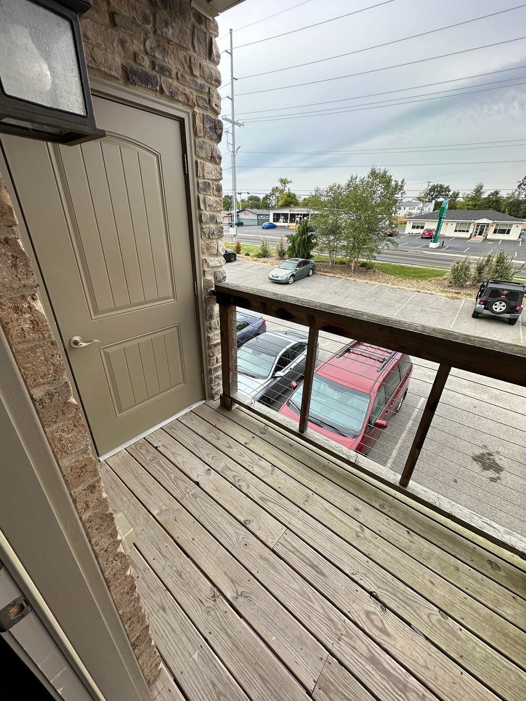 a balcony with a door and a view of a parking lot