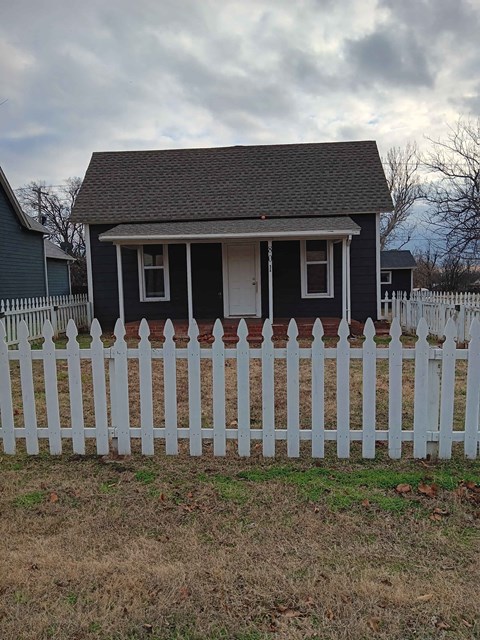 a white picket fence in front of a small house