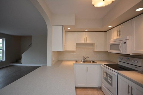a kitchen with white cabinets and a stove and a microwave