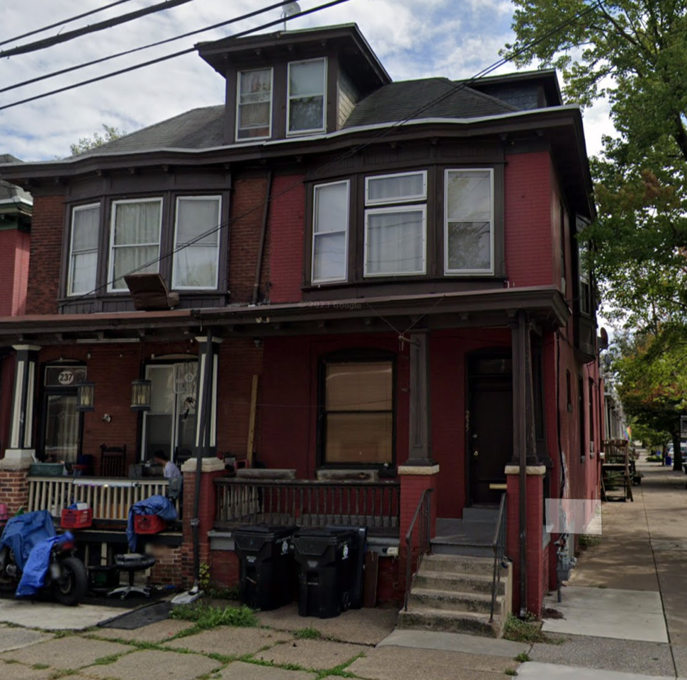 a red house with a lot of trash in front of it