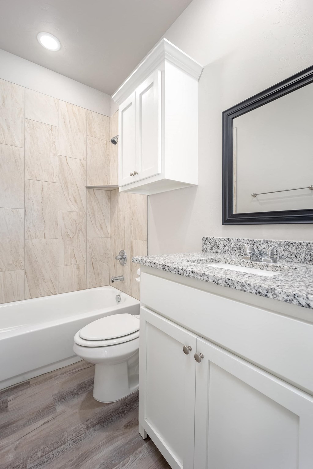 a bathroom with a toilet and a tub and a mirror