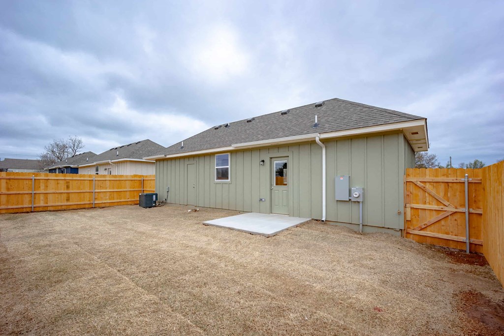 the backyard of a house with a wooden fence and a driveway
