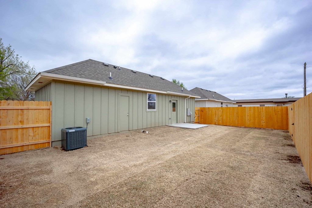 a garage with a gravel driveway and a wooden fence