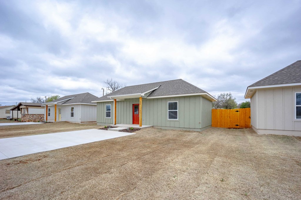 the yard of a home with a parking lot and a fence