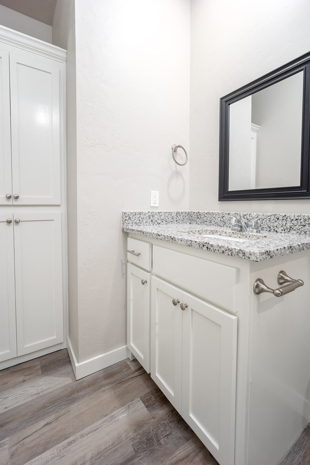 a bathroom with white cabinets and a sink and a mirror