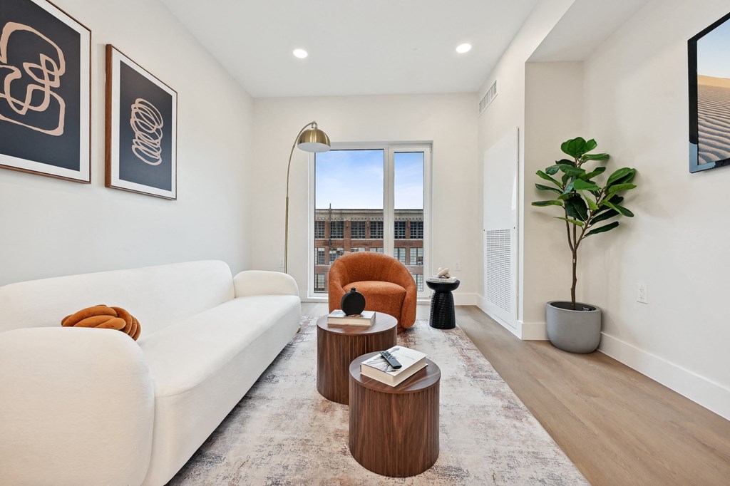 a living room with white furniture and a large window