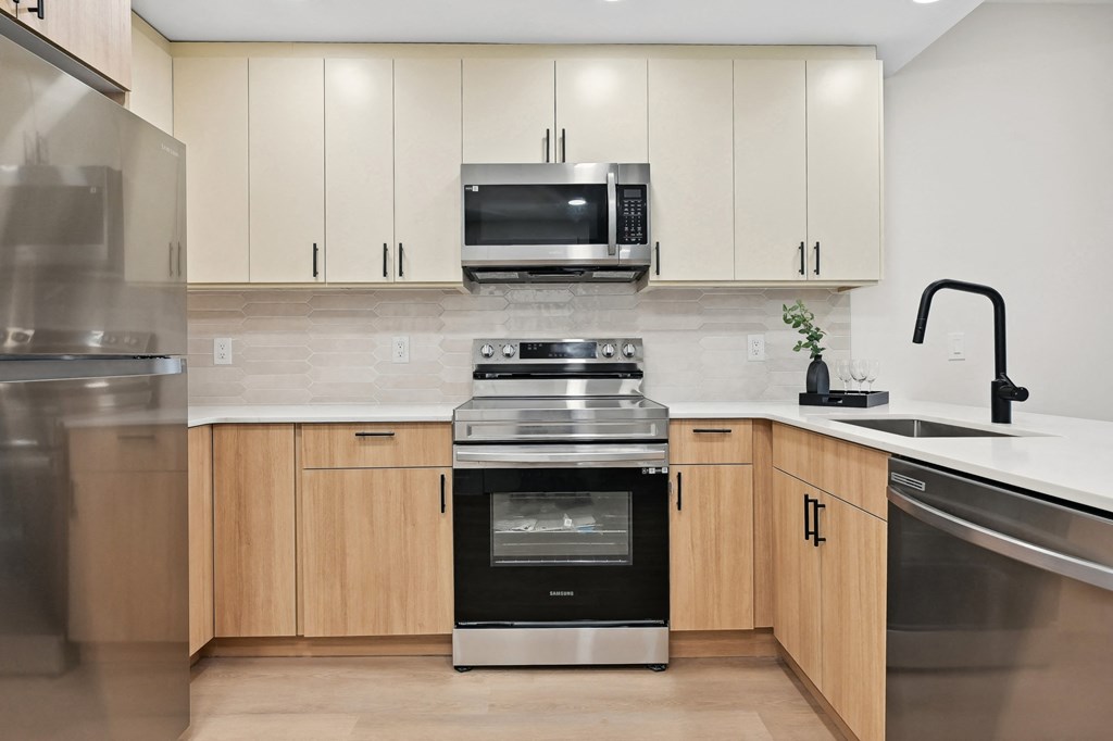a modern kitchen with stainless steel appliances and wooden cabinets