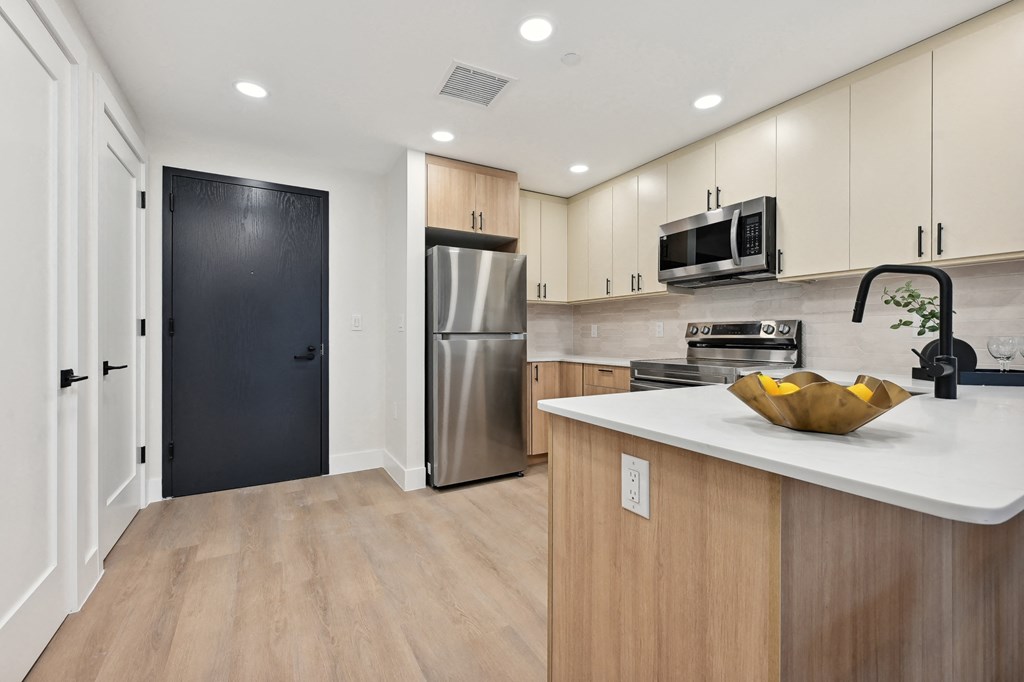 a modern kitchen with stainless steel appliances and a white counter top