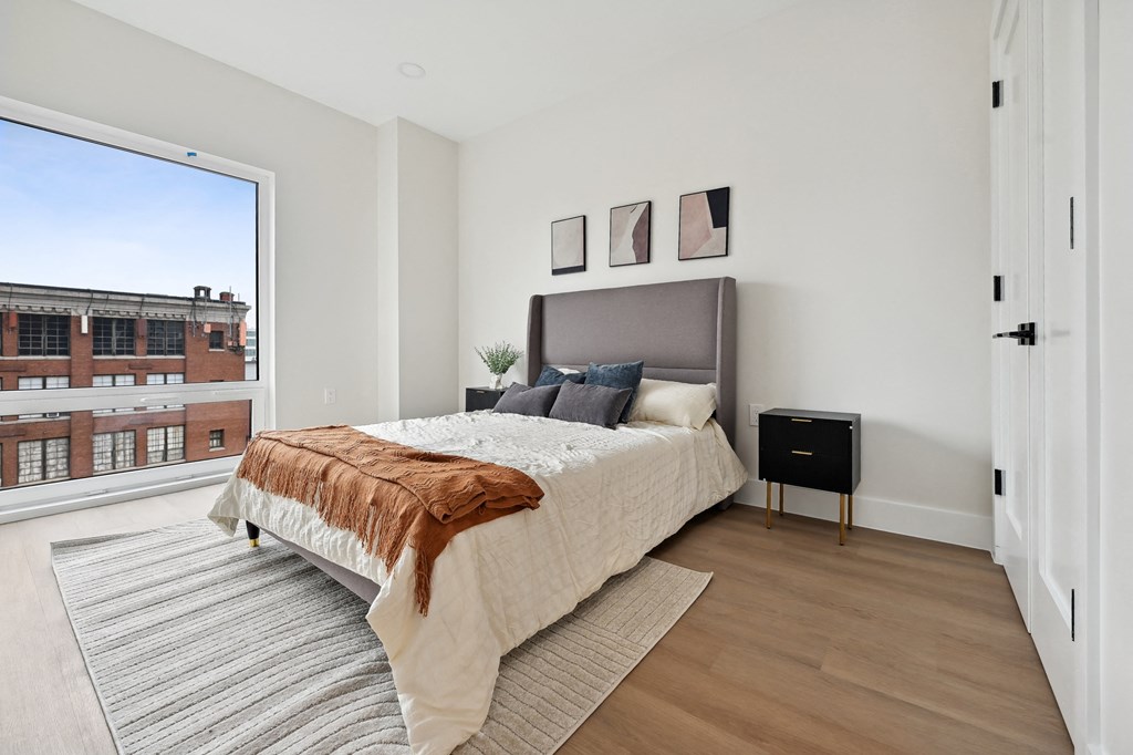 a bedroom with a bed and a large window