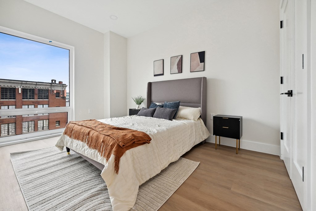 a bedroom with a bed and a large window