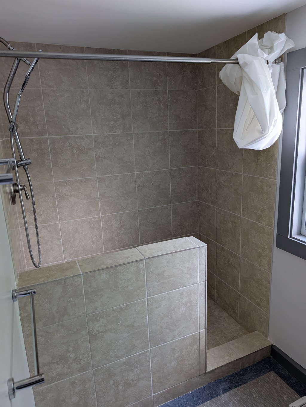 A white towel is hanging on a shower rod.