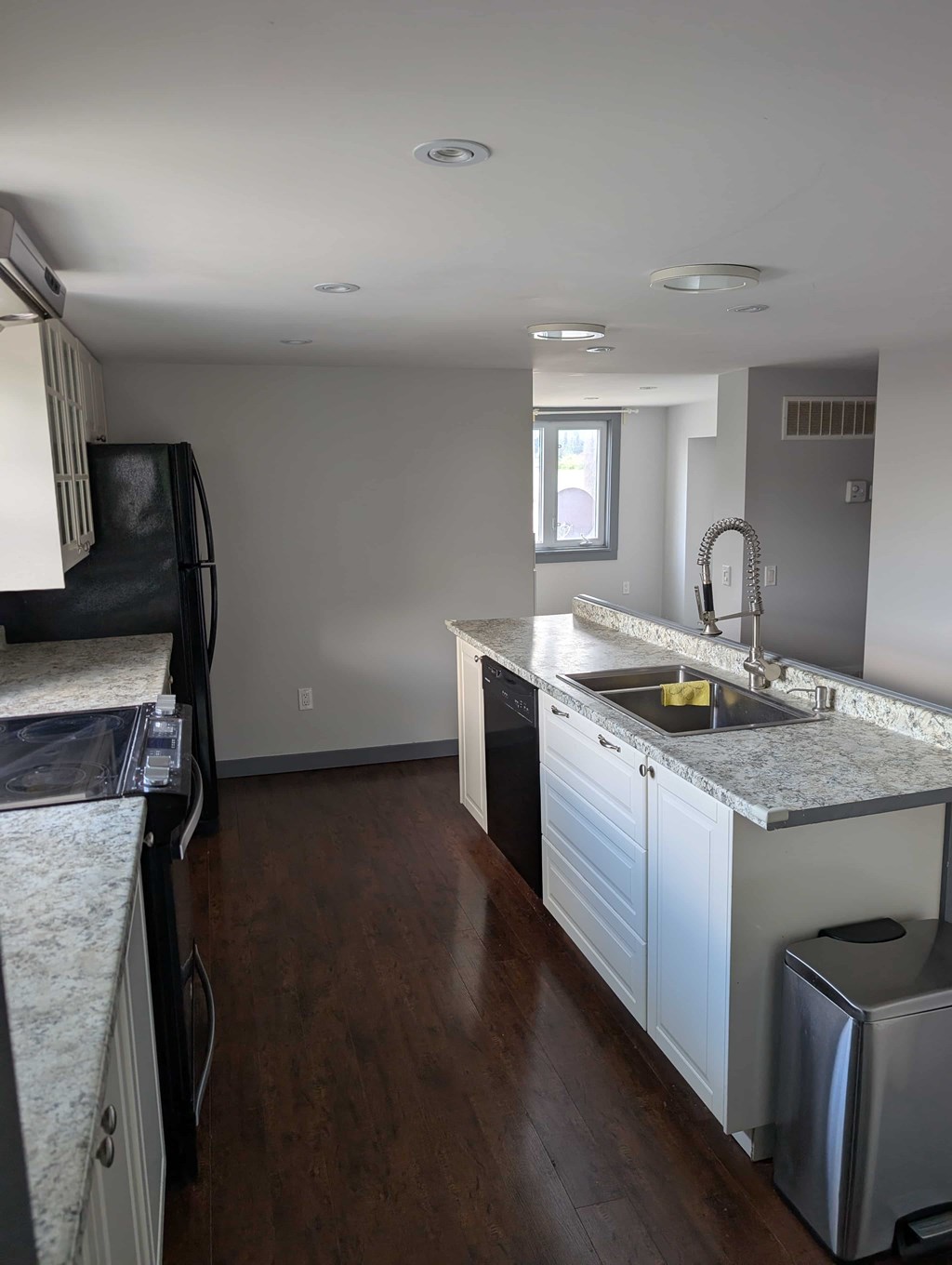 A kitchen with a sink, stove, and cabinets.