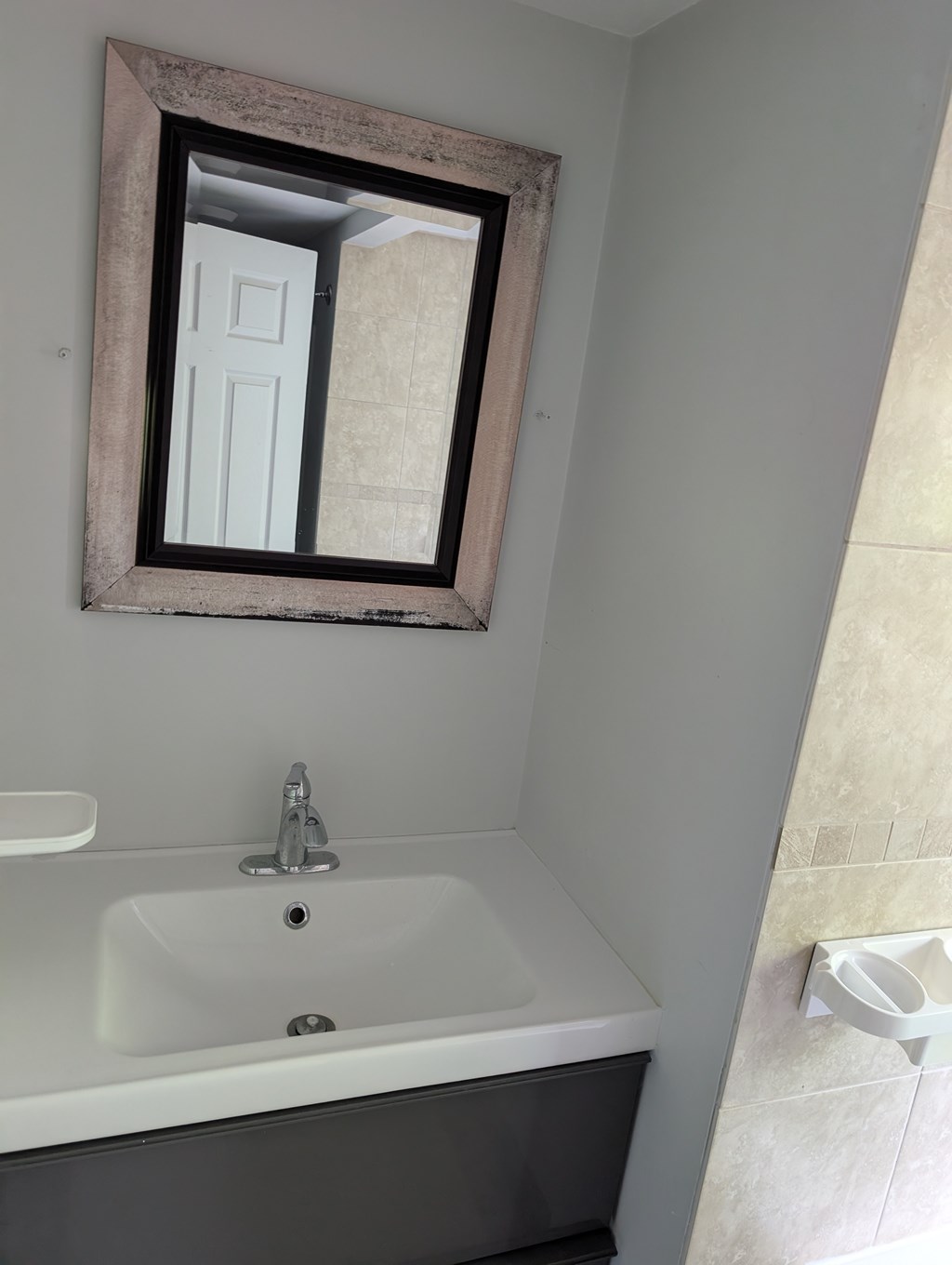 A bathroom with a white sink and a mirror.