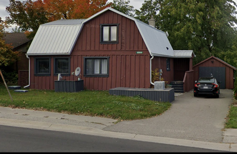 a red house with a car parked in front of it