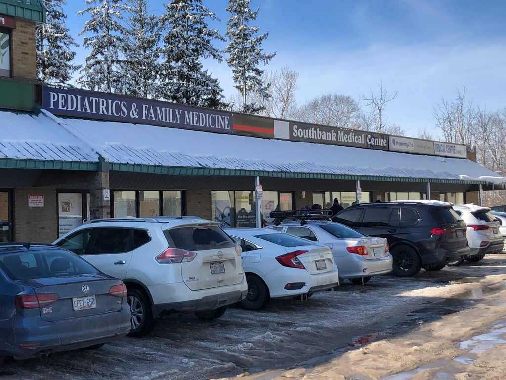 a parking lot full of cars in front of a building with a sign that reads