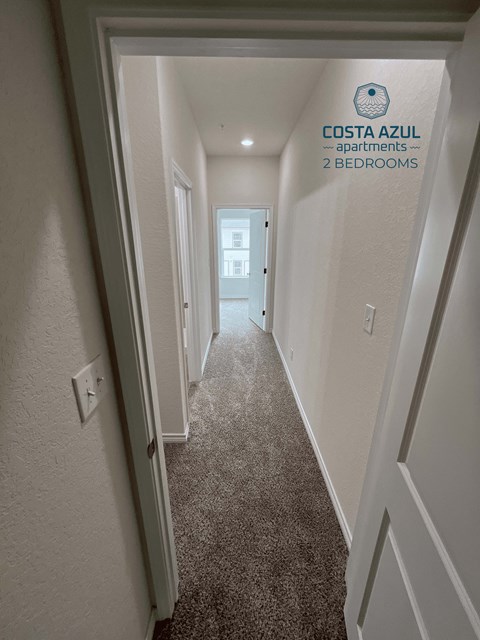 a hallway with white walls and a carpeted floor