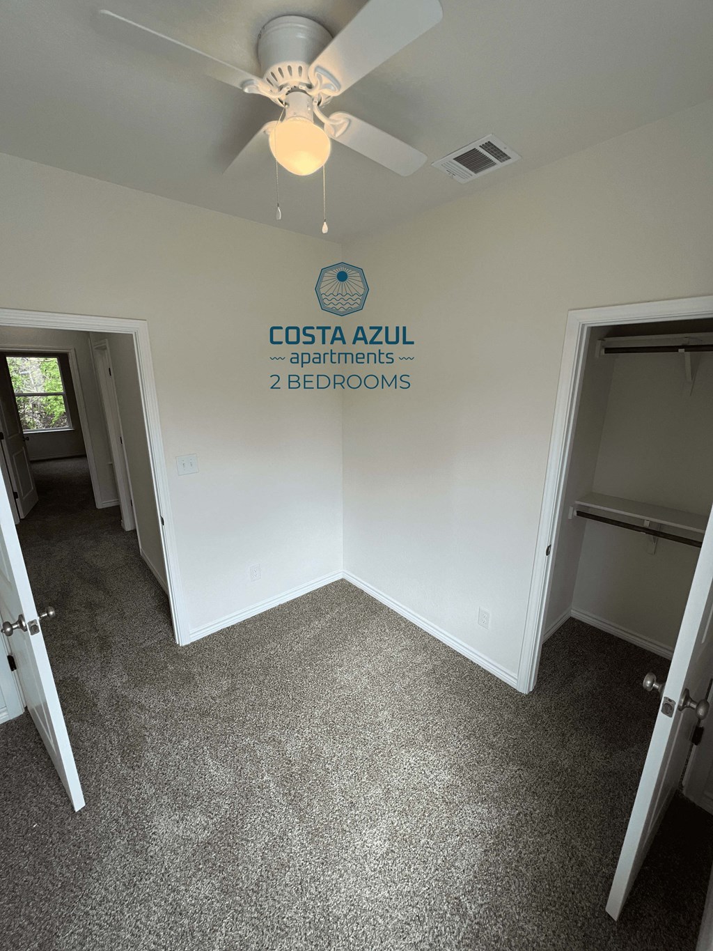 a room with a ceiling fan and a closet