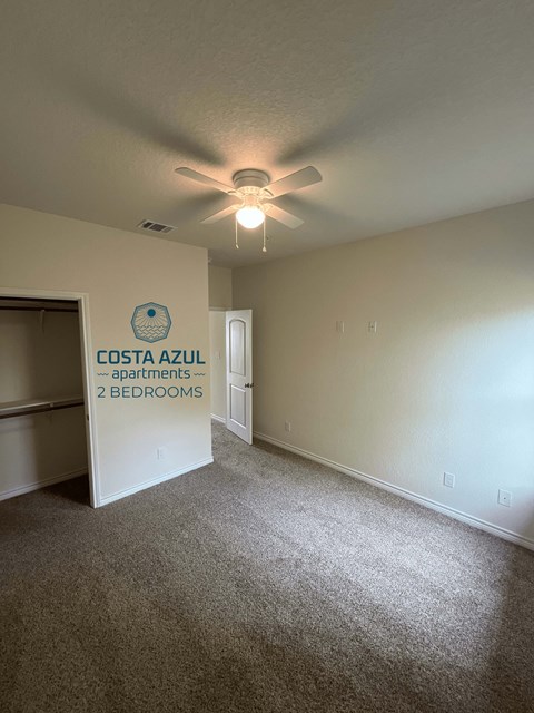 a living room with a ceiling fan and a door to a closet