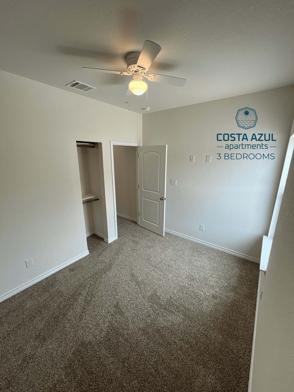 a room with carpeting and a ceiling fan