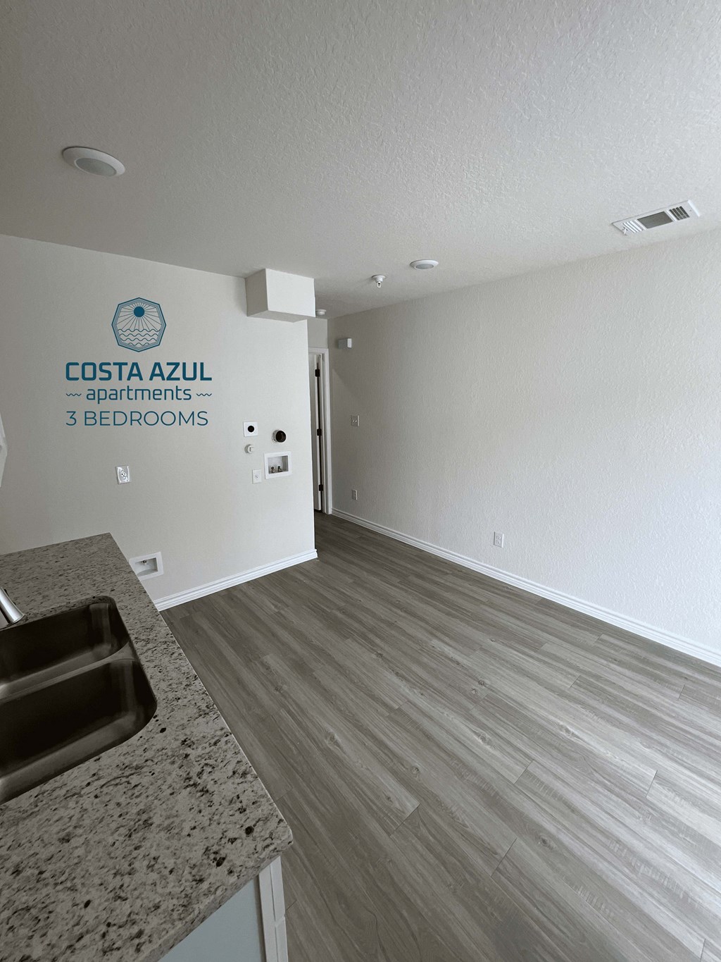 a view from the kitchen into the living room and the hallway to the bedrooms