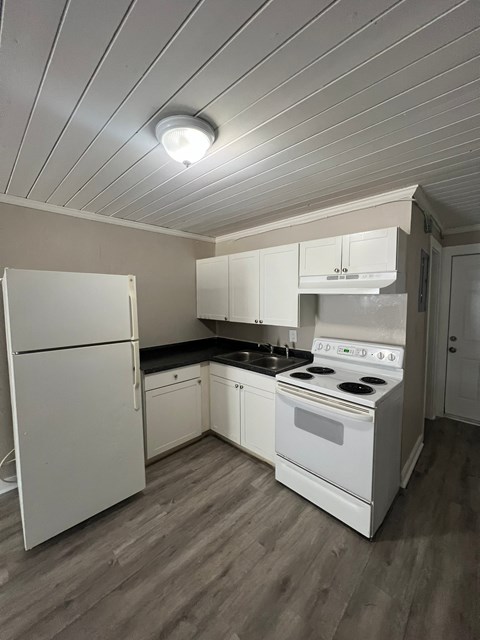 a kitchen with white appliances and white cabinets and a white refrigerator