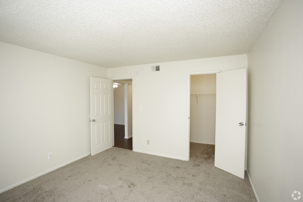 an empty living room with white walls and a door to a closet