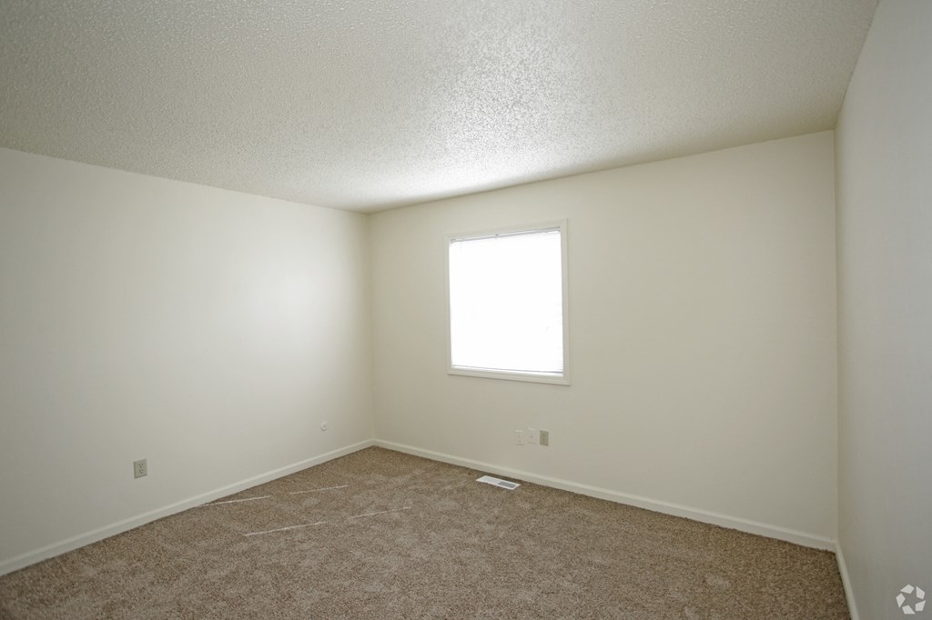 an empty room with carpet and a window