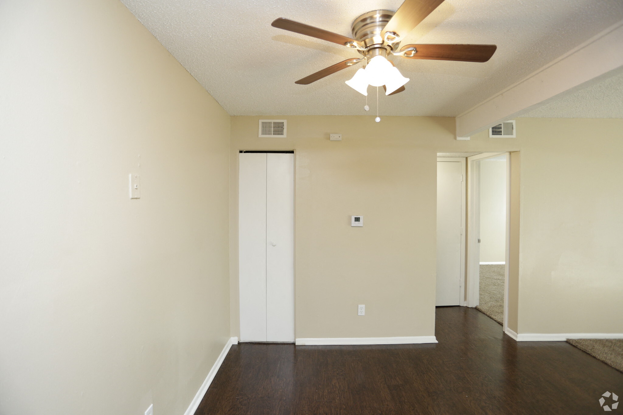Large dark wood panel flooring and utility closet with ceiling fan
