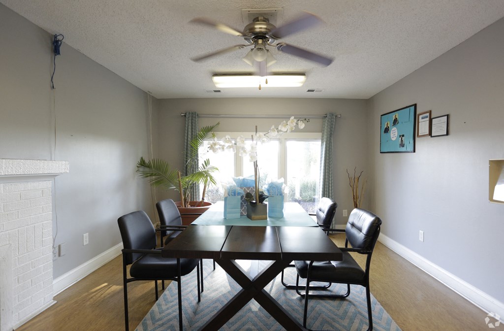 a dining room with a large table and a ceiling fan