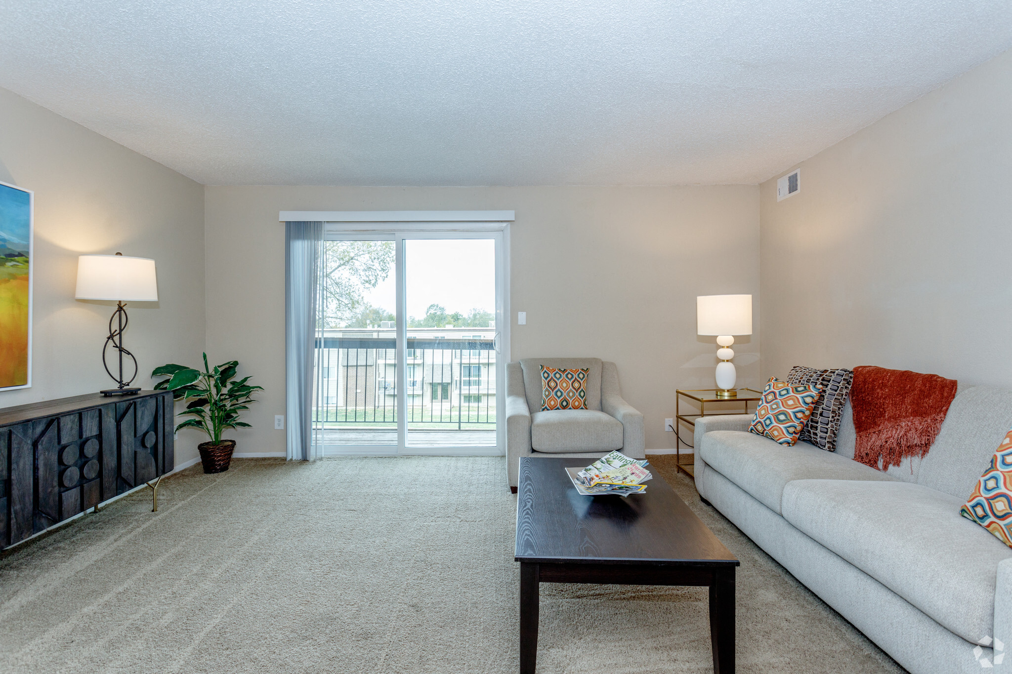 large living room with light grey carpeting with modern lighting on the entertainment center and a light grey couch