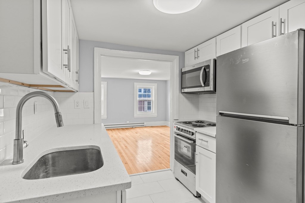 A modern kitchen with stainless steel appliances and white cabinets.
