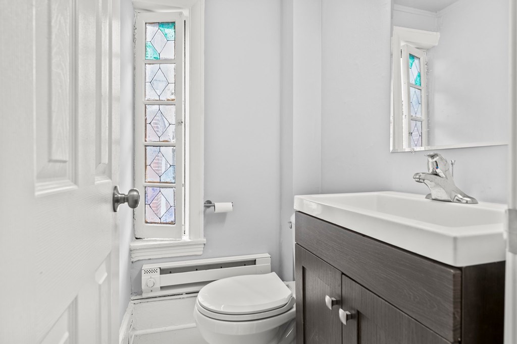 A white toilet sits next to a sink in a bathroom.