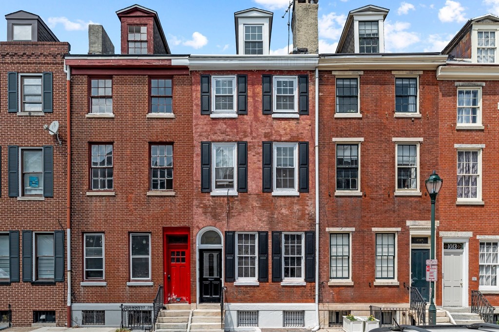 A red brick building with a red door in the front.