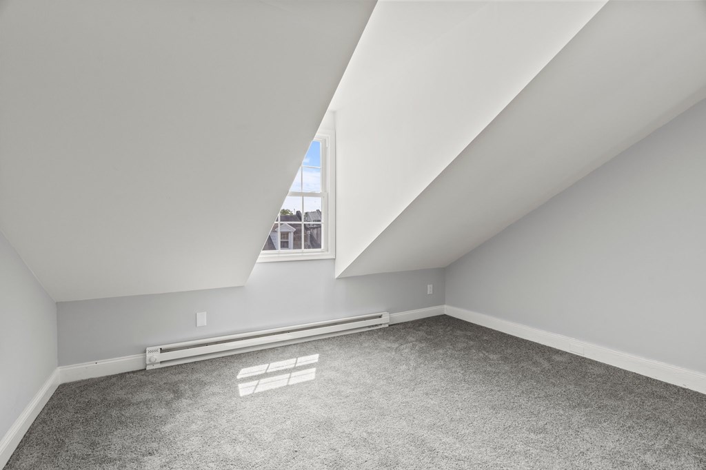 A room with a carpeted floor and a window.