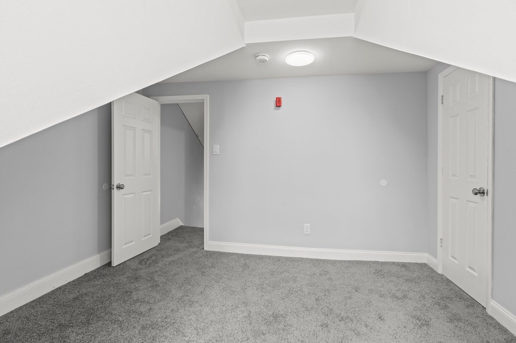 A room with a carpeted floor and white walls.