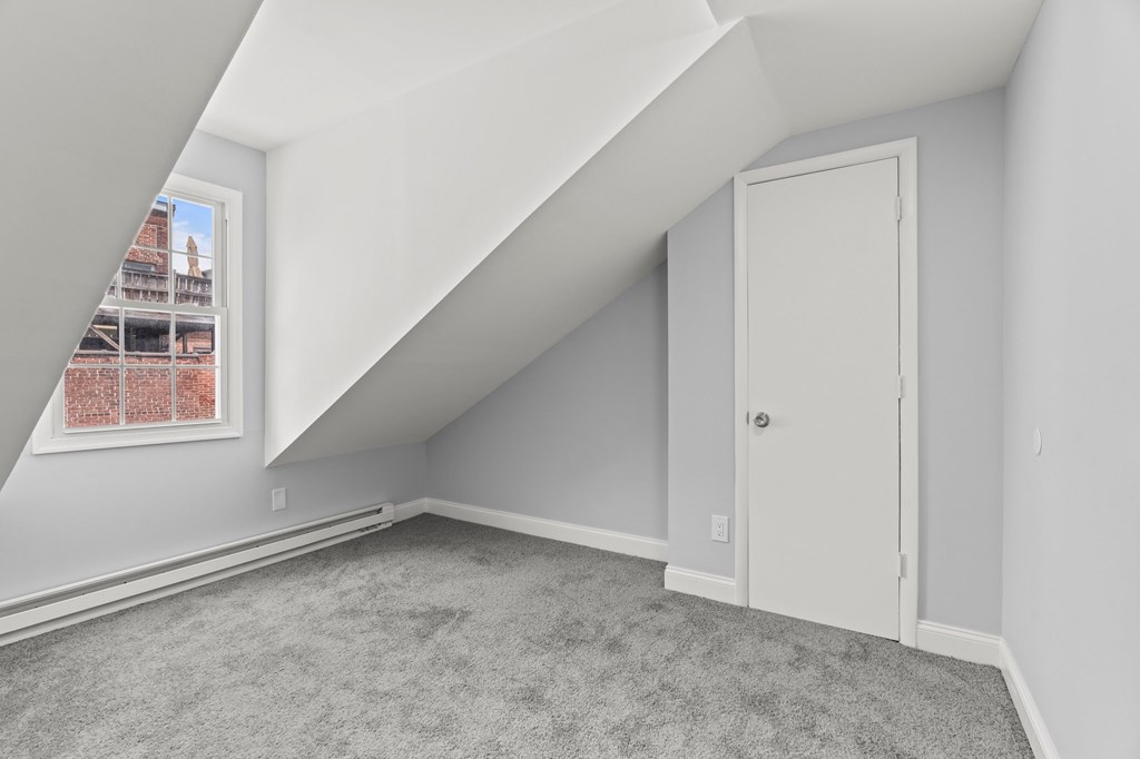 A room with a carpeted floor and a white door.