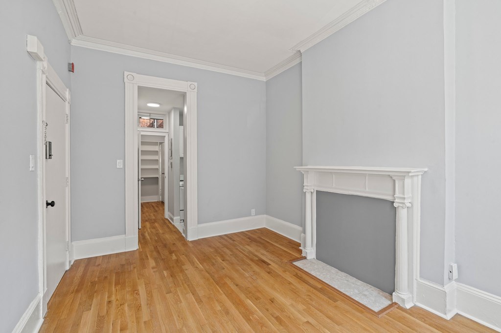 A room with a fireplace and a door on the left.