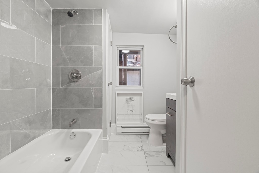A bathroom with a tub, toilet and sink.