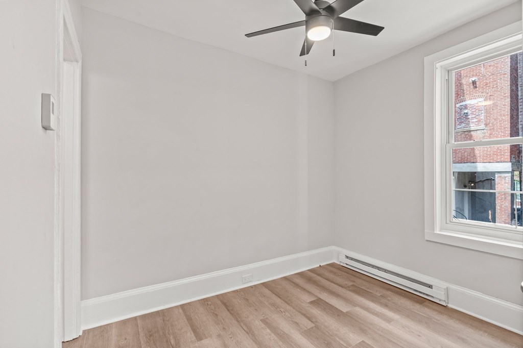 A room with a ceiling fan and a window.