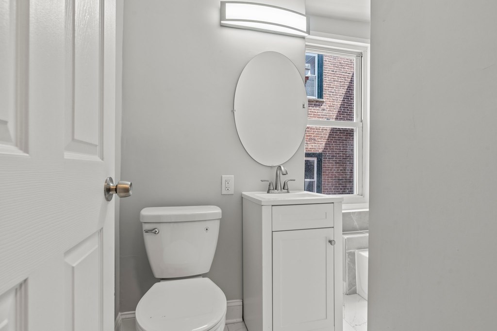 A white toilet sits next to a sink in a bathroom.