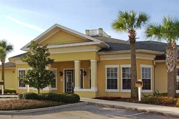 a yellow house with palm trees in front of it