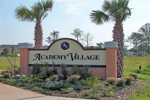 a sign village with palm trees