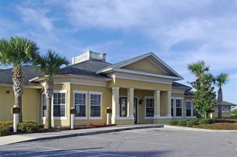 a yellow building with palm trees in front of it